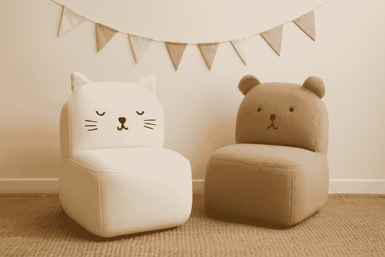 The playful upholstered cat and bear chairs, along with pastel pennant bunting and a cosy rug, create a whimsical children's room