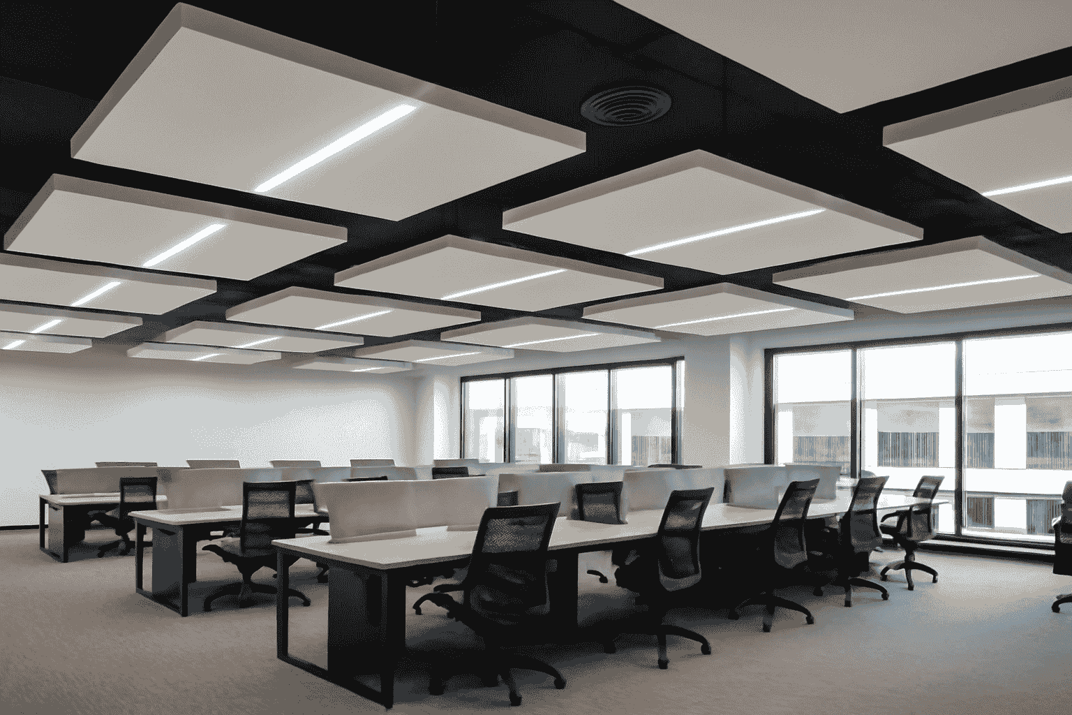 Modern floating ceiling design with recessed LED lights in a spacious office room, featuring light wood desks and grey partitions