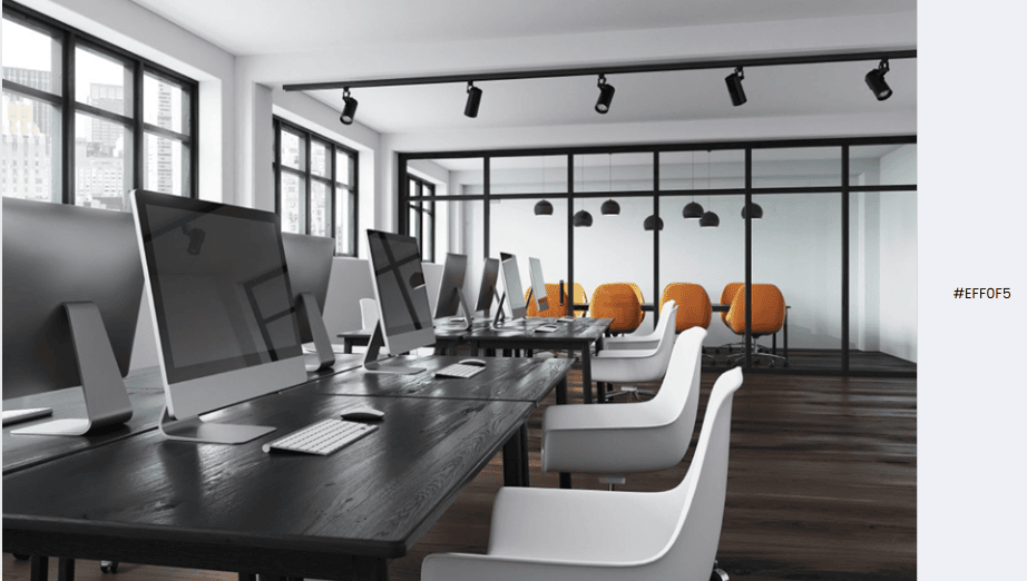 Modern office with sleek black desks, white chairs, and orange accent chairs