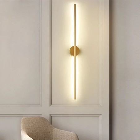 This modern wall light creates a cozy, warm atmosphere with a golden fixture and minimalist design.
