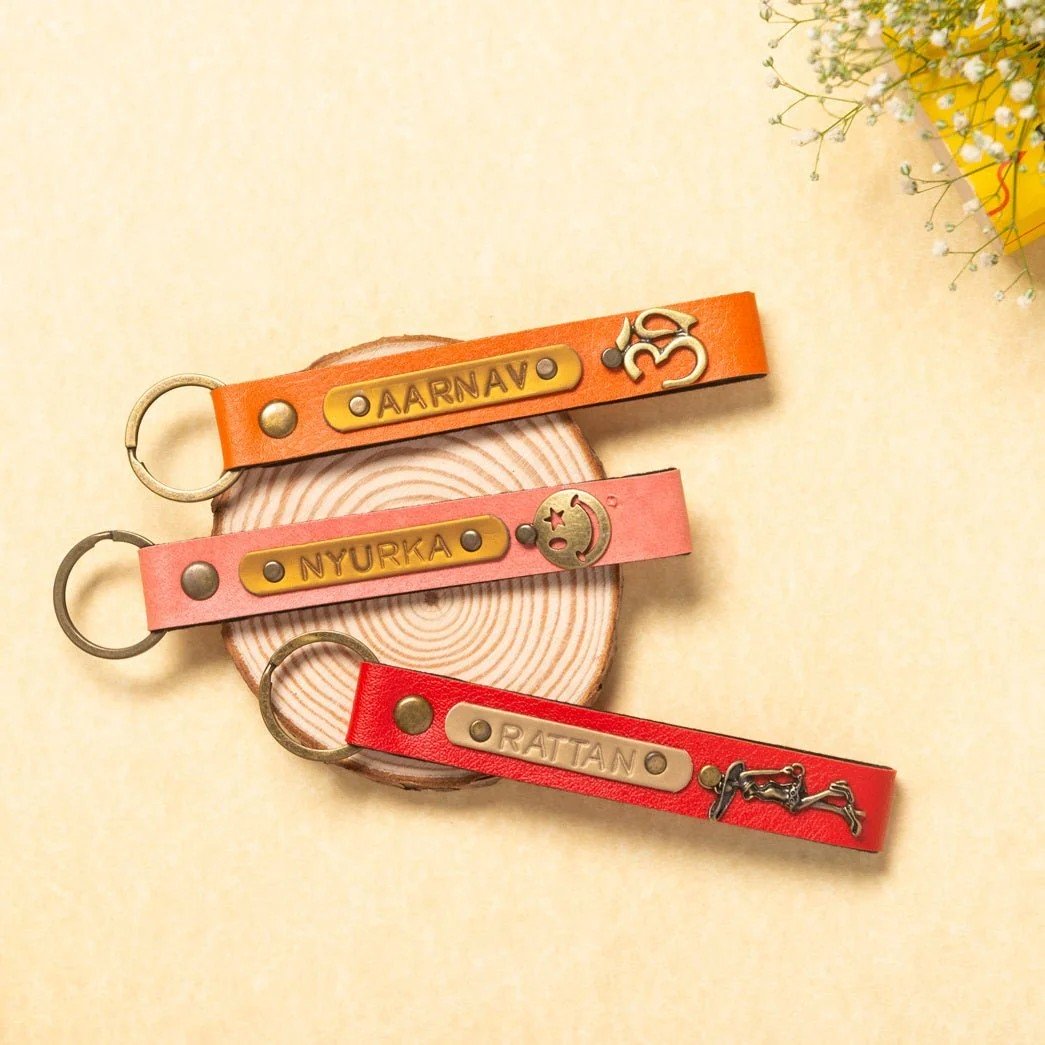 Three leather keychains in orange pink and red with brass name tags perfect for Secret Santa Gift Under 50 AED