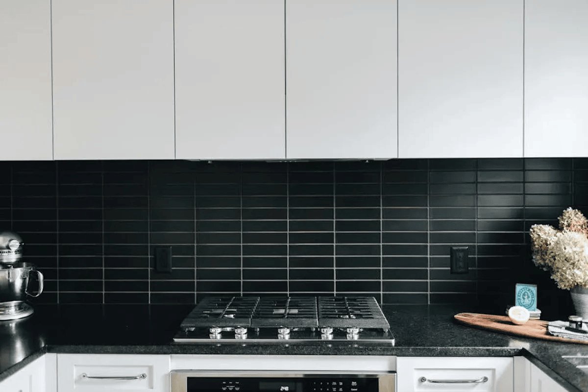 kitchen backsplash features sleek matte black subway tiles with contrasting grout for a bold