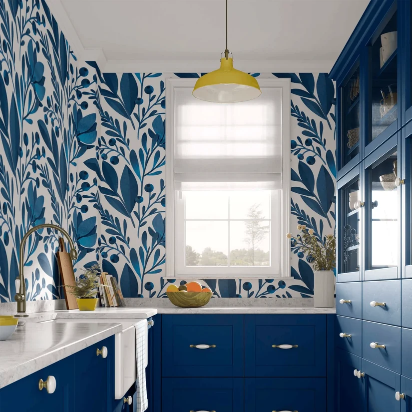 blue botanical kitchen wallpaper around a window with matching blue cabinets