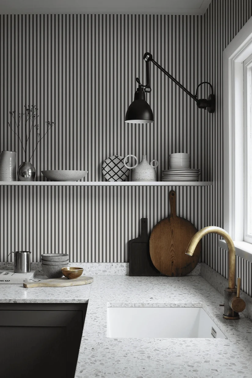 fine grey stripe kitchen wallpaper above a speckled worktop and brass tap